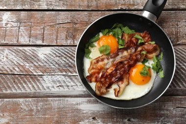 Ahşap masada lezzetli pastırma, yumurta ve maydanoz. Metin için boşluk