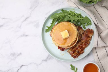 Tereyağlı gözleme, kızarmış pastırma ve beyaz mermer masada taze roka. Metin için boşluk