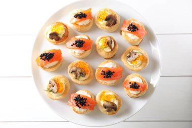 Beyaz ahşap masada farklı lezzetli hamur işi atıştırmalıklar, üst manzara.