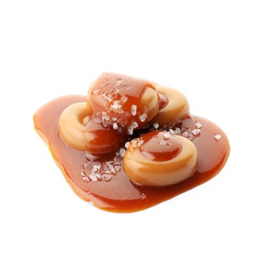 Karamel soslu lezzetli şekerler ve beyaz üzerine izole edilmiş deniz tuzu.