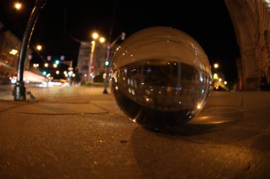 Crystal ball on asphalt road at night. Wide-angle lens