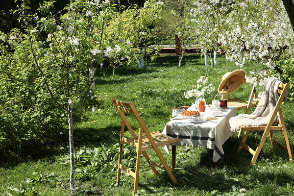Beautiful table setting with spring flowers in garden on sunny day