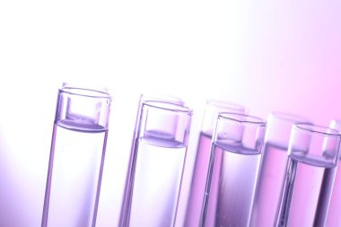 Açık arkaplanda birçok cam test tüpü, yakın plan