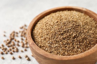 Kasede kişniş tozu, açık gri masada tohumlar, yakın plan.