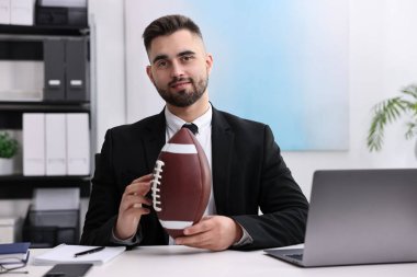 Masada Amerikan futbolu oynayan genç bir adam var.