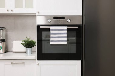 Mutfakta çizgili havluyla elektrikli fırın. Yemek pişirme aygıtı