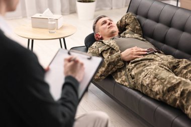 Professional psychotherapist working with military man in office