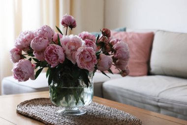 Evdeki masadaki vazoda güzel pembe şakayıklar, mesaj için yer. İç tasarım