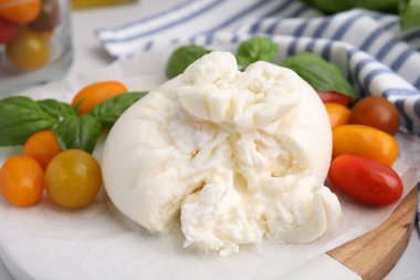 Fesleğen yapraklı ve domatesli leziz taze burrata peyniri, yakın plan.