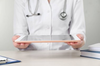 Tabletli doktor ahşap masada, yakın plan.