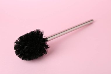 Pembe arka planda bir tuvalet fırçası. Temizlik aracı