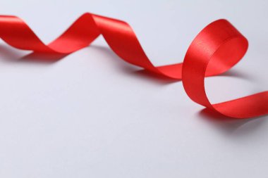 Beyaz arkaplanda güzel bir kırmızı kurdele, metin için boşluk