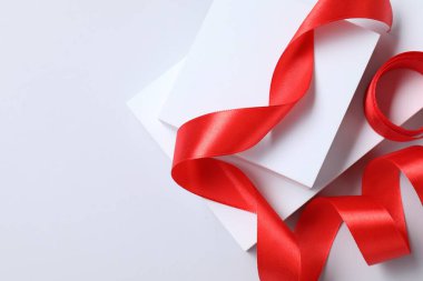 Beyaz arka planda güzel kırmızı kurdele ve podyumlar, üst manzara. Metin için boşluk