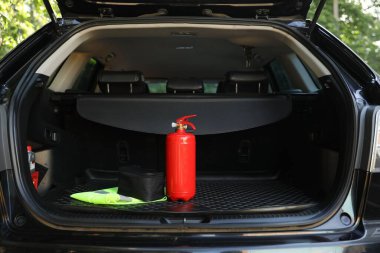 Bagajda kırmızı yangın söndürücü var. Araba güvenliği ekipmanı