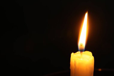 Siyah arka planda yanan bir kilise mumu, yakın plan. Metin için boşluk
