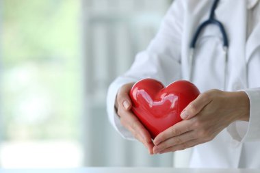 Klinikte kırmızı kalpli bir doktor, yakın plan. Metin için boşluk