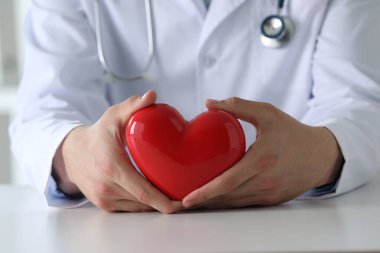 Kırmızı kalpli doktor beyaz masada, yakın plan.