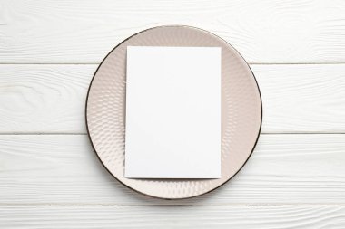 Boş menü ve tabak beyaz ahşap masa, üst manzara. Tasarım için model