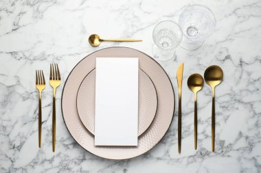 Boş menü, çatal bıçak takımı, bardaklar ve tabaklar beyaz mermer masa, düz yatak. Tasarım için model