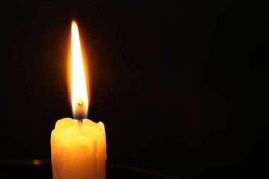 Siyah arka planda yanan bir kilise mumu, yakın plan. Metin için boşluk