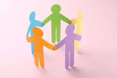 Eşitlik kavramı. Pembe arka planda kağıt insan figürleri, yakın plan
