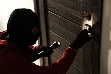 El fenerli bir hırsız holdeki yabancı kapının kilidini kırıyor. Hırsızlık.