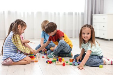 Bir grup çocuk içeride birlikte oynuyorlar.