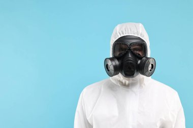 Açık mavi arka planda gaz maskeli bir işçi. Metin için boşluk