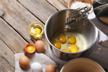 Para kazanmak. Kase dolusu çiğ yumurta karıştırıcı ve ahşap masadaki malzemeler.