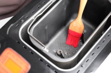 Masadaki ekmek makinesine yağ sürüyorum, yakın plan.