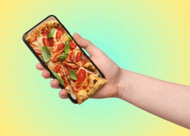 Çevrimiçi yemek siparişi. Ekranda pizza ile akıllı telefonu tutan kadın renk değişimine karşı, yakın plan. Bir dilim cihazdan çıkmış.