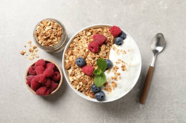 Gri desenli masada servis edilen böğürtlenli ve yoğurtlu lezzetli granola.