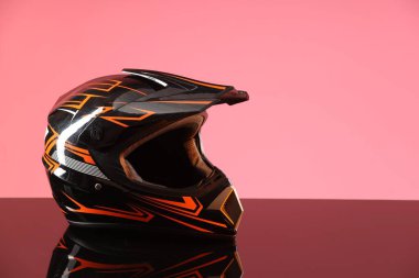 Ayna yüzeyinde pembe arka planda güneşliği olan modern motosiklet kaskı. Metin için boşluk