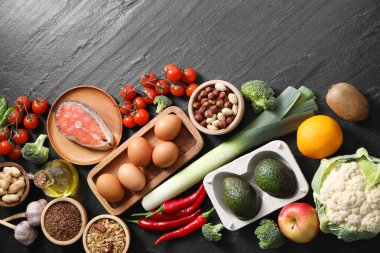 Koyu dokulu masa üzerinde pek çok farklı sağlıklı yiyecek, düz yatıyordu.