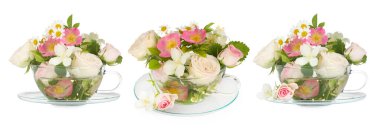 Fincanlarda lezzetli bitki çayı ve beyaz arka planda güzel çiçekler.