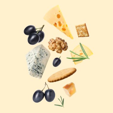 Bej arka planda farklı peynir, kraker, üzüm, biberiye ve ceviz çeşitleri