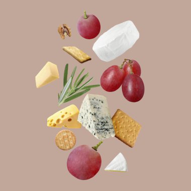 Farklı peynir, kraker, üzüm, biberiye ve ceviz çeşitleri koyu bej arka planda.