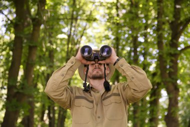 Dürbünlü Forester ormandaki bitkileri inceliyor.