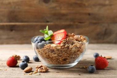 Böğürtlenli, fındıklı ve ahşap masadaki nane aromalı granola.