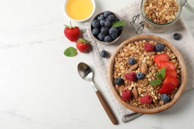 Böğürtlenli granola, fındık ve nane şekerli beyaz masa, düz yatak. Metin için boşluk