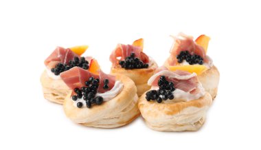 Delicious puff pastry with cream cheese, ham, black caviar and peach isolated on white clipart