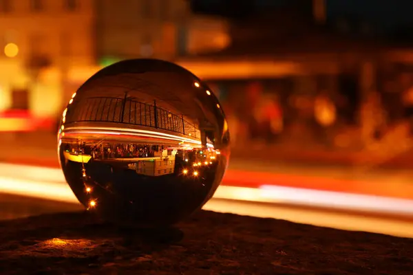 stock image Beautiful city street, overturned reflection. Crystal ball at night, closeup. Space for text