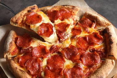 Gri masada lezzetli biberli pizza yiyorum, yakın plan.