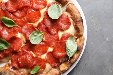 Lezzetli biberli pizza. Fesleğenli, gri masa, üst manzara.