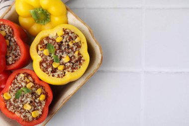 Quinoa dolma dolma dolma dolma biber ve fesleğen, beyaz fayanslı masa, üst manzara. Metin için boşluk