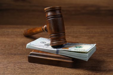 Tahta masada yığınla doları olan kanun tokmağı, yakın plan.