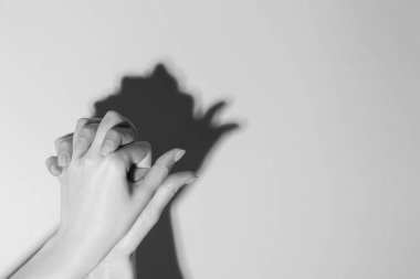 Kadın hafif arka plandaki kuş gibi el hareketi yapıyor, mesaj için yere yakın çekim yapıyor. Siyah ve beyaz etkisi