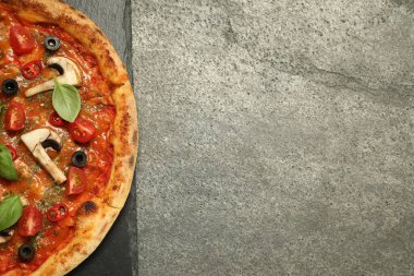 Lezzetli pizza fesleğenli, zeytinli ve domatesli gri desenli masa, üst manzara. Metin için boşluk