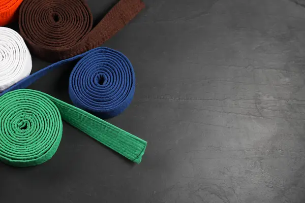 stock image Colorful karate belts on gray background, flat lay. Space for text