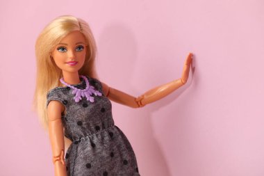 Mykolaiv, Ukrayna - 4 Eylül 2023: Mor arka planda kolye takan güzel Barbie bebek, metin için yer